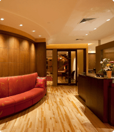 Office reception area with hard wood floors and clean red couch